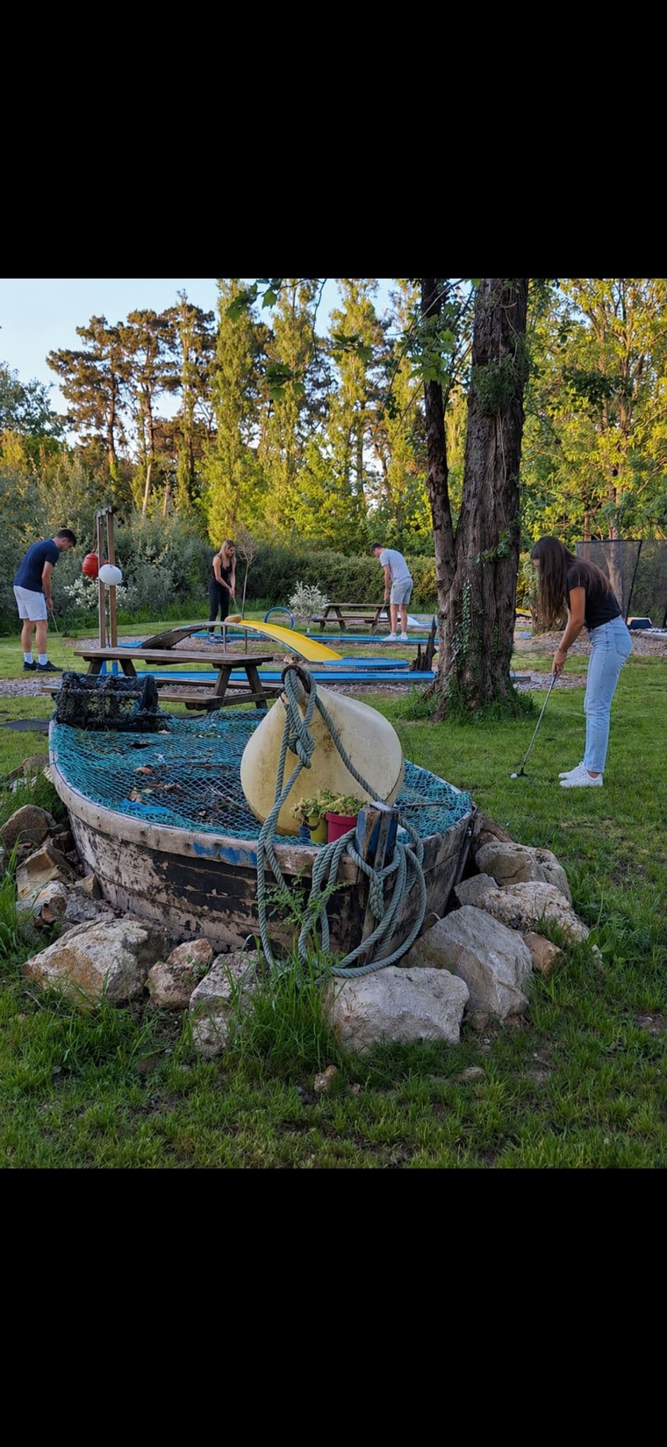 Joueurs au mini-golf au coucher du soleil